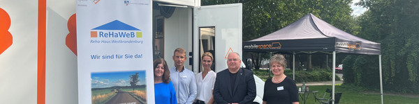 Fünf Personen stehen vor dem Beratungsmobil, im Hintergrund steht ein Pavillon mit Sitzmöglichkeiten - Klick öffnet Bildbetrachter