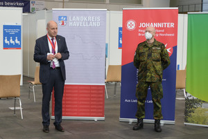 Zwei Männer stehen nebeneinander vor einem Aufsteller mit der Aufschrift "Landkreis Havelland".