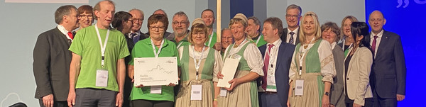 Eine Delegation aus Garlitz steht auf der Bühne bei der Grünen Woche in Berlin.