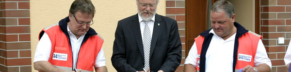 Jörg Grigoleit, Dr. Burkhard Schröder und der technische Einsatzleiter Andreas Büttner zerschnitten das obligatorische Band zur Eröffnung der neuen Rettungswache.