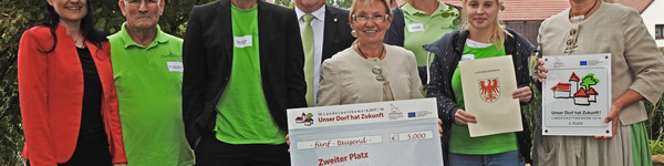 Als Zweitplatzierter erhält der Ort Garlitz einen Scheck von 5.000 Euro. Der Siegerehrung wohnten auch Amtsdirektorin Ilka Lenke (links im Bild) und Dennis Granzow, Dezernent im Landkreis bei, © Landkreis Havelland