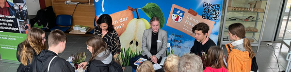 Klick öffnet Nachricht, an zwei Informationstischen stehen zahlreiche junge Menschen