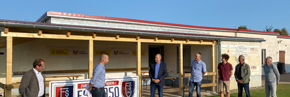 Sieben Männer stehen vor dem Vereinsgebäude.