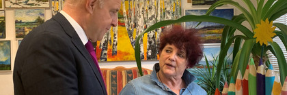 Zwei Personen stehen in einem Atelier und unterhalten sich - Klick öffnet Bildbetrachter