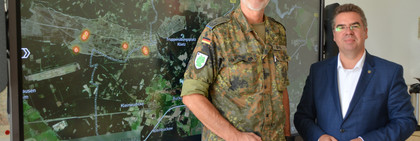 Zwei Personen stehen vor einem großen Bildschirm, der eine Landkarte anzeigt - Klick öffnet Bildbetrachter