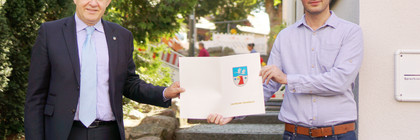 Roger Lewandowski und Károly Bakó zeigen den Fördermittelbescheid.