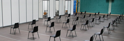 Blick in die Havellandhalle, wo leere Stuhlreihen vor den zukünftigen Impfkabinen stehen.