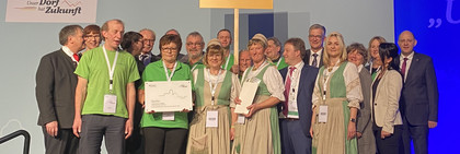 Eine Delegation aus Garlitz steht auf der Bühne bei der Grünen Woche in Berlin.