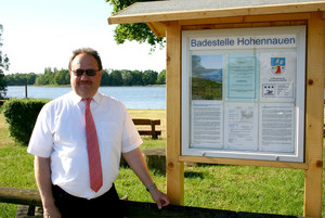Amtsarzt Dr. Erich Hedtke mit der Hinweistafel am Hohennauener See.