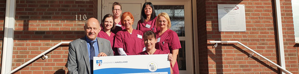 Klick öffnet Bildbetrachter, eine Gruppe von Menschen vor einem Gebäudeeingang