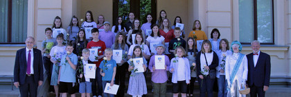 Eine größere Gruppe steht auf einer Trepppe.