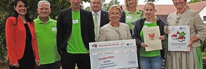 Als Zweitplatzierter erhält der Ort Garlitz einen Scheck von 5.000 Euro. Der Siegerehrung wohnten auch Amtsdirektorin Ilka Lenke (links im Bild) und Dennis Granzow, Dezernent im Landkreis bei, © Landkreis Havelland