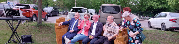 Klick öffnet Bildbetrachter; Personen auf einer Bank sitzend