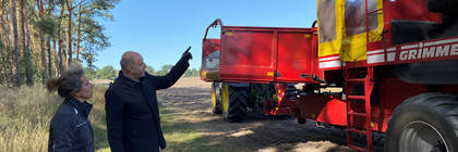 Annette Brockmann und Roger Lewandowski stehen vor einer Landwirtschaftsmaschine.