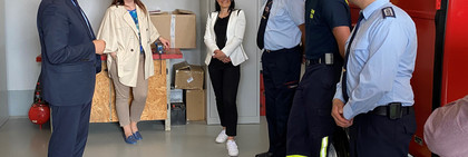 Der Landrat und einige andere Personen stehen im Feuerwehrgerätehaus und unterhalten sich.