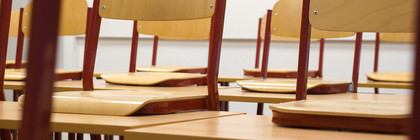 Blick in einen leeren Klassenraum: Die Stühle sind auf den Tischen abgestellt.