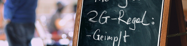 Ein Aufsteller mit der Aufschrift "Hier gilt 2G-Regel: geimpft oder genesen".