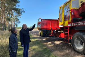 Annette Brockmann und Roger Lewandowski stehen vor einer Landwirtschaftsmaschine.
