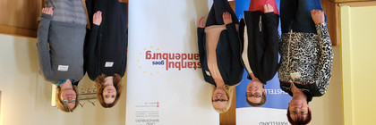 Klick öffnet Text, fünf Frauen vor Plakaten