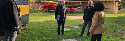 Vier Personen stehen in einigem Abstand auf einem Hof und unterhalten sich.