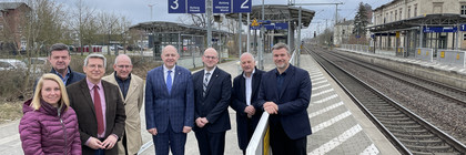 Eine Gruppe von Menschen steht auf einem Bahnsteig - Klick öffnet Bildbetrachter