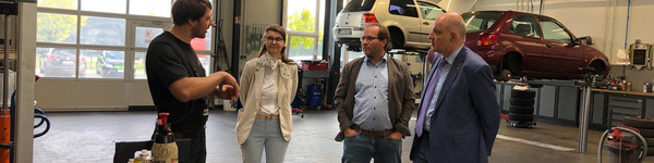 Klick öffnet Artikel, vier Personen in einer Autowerkstatt