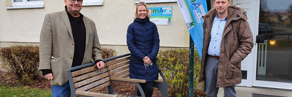 Drei Personen stehen vor dem Wohnblock, in dem sich die Musterwohnung befindet.