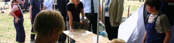 Ministerin Dagmar Ziegler, der Vorsitzende des Kreisfeuerwehrverbandes Frank Pfuhl und der Beigeordnete Dr. Henning Kellner kamen anlässlich der Eröffnung des Jugendlagers auch mit Kindern und Jugendlichen ins Gespräch.