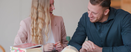 Zwei junge Menschen sitzen an einem Tisch und lernen gemeinsam