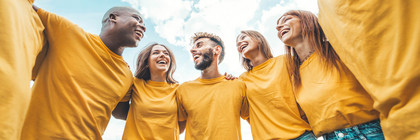 Klick öffnet Text; Gruppe von Menschen umarmen sich