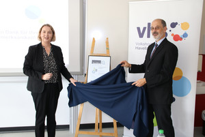 Elke Nermerich und Dr. Frank Dittmer enthüllen das mit einem Tuch verdeckte Zertifikat.