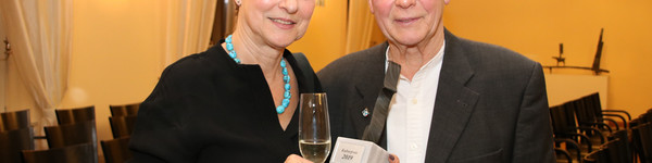 Annette und Gerhard Göschel stehen nebeneinander und zeigen die Skultptur des Kulturpreises.