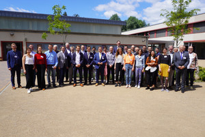 Eine Gruppe von rund 40 Menschen steht versammelt auf einer Freifläche und schaut in die Kamera - Klick öffnet Bildbetrachter