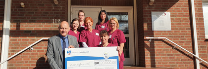 Klick öffnet Bildbetrachter, eine Gruppe von Menschen vor einem Gebäudeeingang