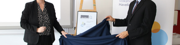 Elke Nermerich und Dr. Frank Dittmer enthüllen das mit einem Tuch verdeckte Zertifikat.