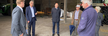 Eine Gruppe von Menschen steht im Kreis in einer Scheune.