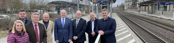 Eine Gruppe von Menschen steht auf einem Bahnsteig - Klick öffnet Bildbetrachter
