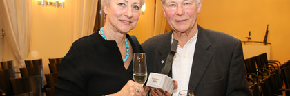 Annette und Gerhard Göschel stehen nebeneinander und zeigen die Skultptur des Kulturpreises.