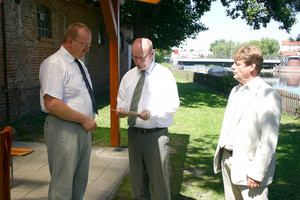 Andreas Ernst (Mitte) überreicht im Beisein des stellvertretenden Bürgermeister der Stadt Rathenow Hans-Jürgen Lemle (re.) den Förderbescheid an Klaus Sommerfeld, Vorsitzender des Rathenower Ruder Club Wiking.