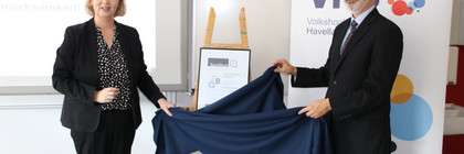 Elke Nermerich und Dr. Frank Dittmer enthüllen das mit einem Tuch verdeckte Zertifikat.