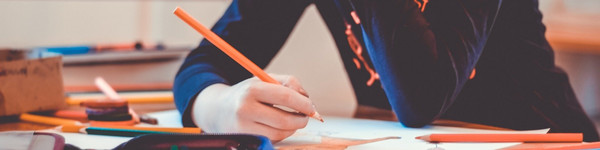 Ein Kind sitzt im Klassenzimmer und malt.