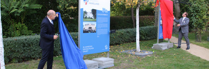 Landrat Roger Lewandowski und Nauens Bürgermeister Manuel Meger enthüllen zwei der Stelen, die mit einem Tuch verhüllt waren.