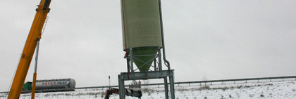 Der erste von zwei Silos wird vom Schwerlasttransport aufgehoben und an seinen endgültigen Standort gehievt.