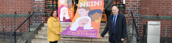 Vier Personen stehen verteilt auf einer Treppe und halten die Fahne zum Aktionstag.