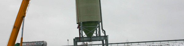 Der erste von zwei Silos wird vom Schwerlasttransport aufgehoben und an seinen endgültigen Standort gehievt.