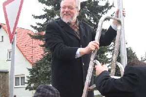 Selbst ist der Mann: Landrat Schröder befestigt das letzte Schild des neuen Leitsystems