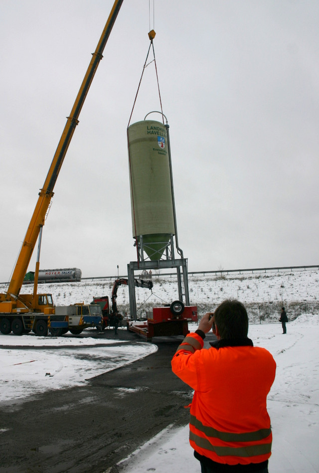 Der erste von zwei Silos wird vom Schwerlasttransport aufgehoben und an seinen endgültigen Standort gehievt.