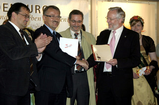 Dr. Burkhard Schröder (re.) überreicht Dr. Gerd Lehmann (2. v. li.) im Beisein von Ministerpräsident Matthias Platzeck und Minister Jörg Vogelsänger die Abtretungsurkunde für Geschäftsanteile an der MAFZ GmbH.