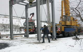 In Millemeterarbeit wird der gewaltige Silo in das vorbereitete Fundament eingeführt und dort verankert.