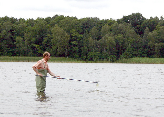 Mit einem Probennahmestab werden Wasserproben aus den untersuchten Gewässern entnommen.